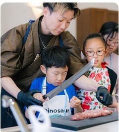料理体験で包丁の使い方を教わる子どもたち